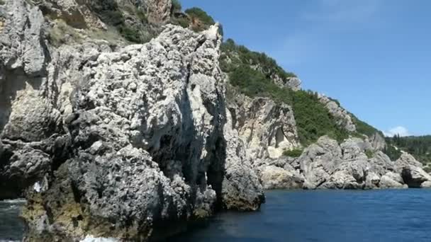 ボートの旅はパレオカストリッツア コルフ島 ギリシャ Liapades ビーチへ 水の中の土砂チョーク岩を渡しです 森と崖の海岸 — ストック動画