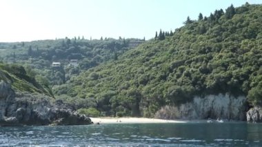 Rovinia Beach Paradise beach bölgesinde Korfu Adası'nda bir tekne ile ileterek. İnsanlar plajda. Liapades köyün yanında yer. (Yunanistan)