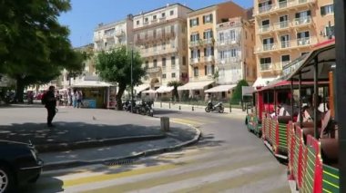 Corfu town, Corfu / Yunanistan 01 Haziran 2018: Cityscape, Corfu Town (Yunanistan) geleneksel evleri ve sokakları ile. Restoranlar ve mağazalar tarafından geçen bir şehir tren, sürüş.