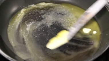 krep pişirmek için bir tavada tereyağı eritme.