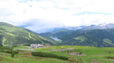 Tirol Avusturya Isskogel dağ zirvesinde niçin yağmur bulutları zaman atlamalı. Teleferik istasyonunun yanında dolaşan insanlar.