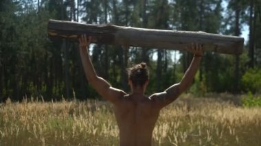 Güçlü bir adam bir ağaç kaldırır, bir adam açık havada spor için gider