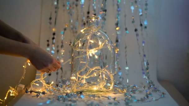 Chica decorando un fondo de guirnalda, fondo de Navidad brillante con luces — Vídeos de Stock