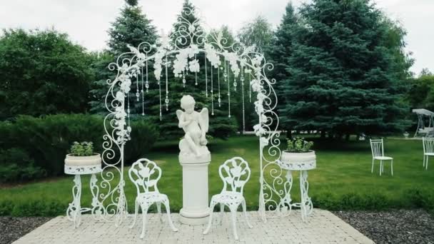 Estátua de um menino anjo em um pedestal, decorado com um parque infantil para umas férias — Vídeo de Stock