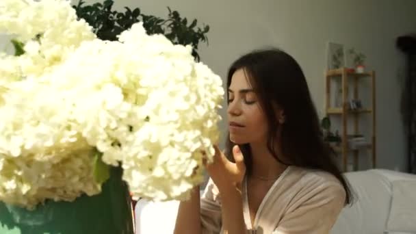 La fille sent un grand bouquet de fleurs. Fille et fleurs. Arôme de fleurs . — Video