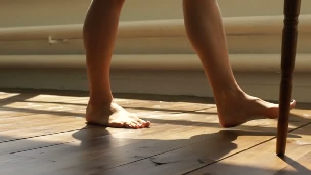 La chica está caminando por el suelo de madera. Pies femeninos van en el suelo de madera . — Vídeos de Stock