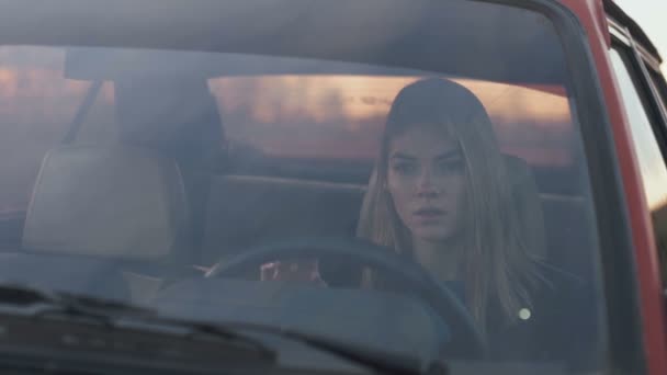 La fille tend la main vers l'avant, assise dans la voiture, mélancolique — Video