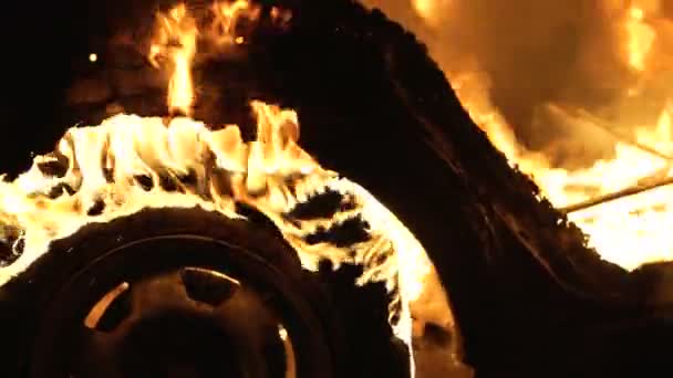 Une roue brûle dans une voiture la nuit, des pneus de voiture brûlent, gros plan — Video