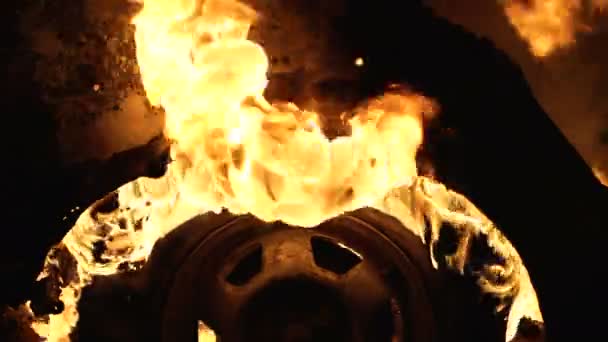 Una rueda arde en un coche por la noche, neumáticos del coche arden, primer plano — Vídeos de Stock
