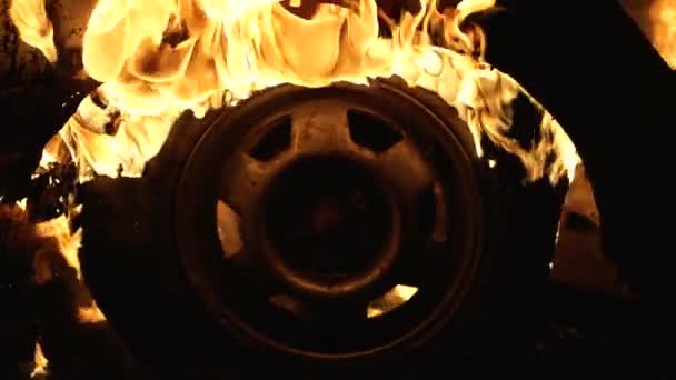 Koło spala się w samochodzie w nocy, palić opony samochodowe, zbliżenie — Wideo stockowe