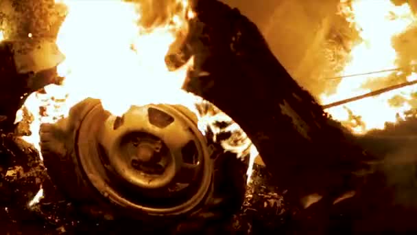 Una rueda arde en un coche por la noche, neumáticos del coche arden, primer plano — Vídeos de Stock