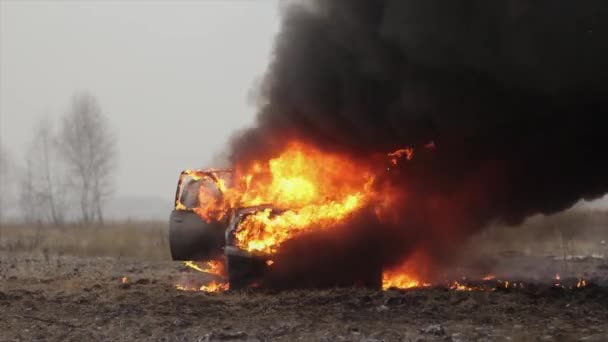 Samochód w ogniu, spalanie samochodu w pole, przedni widok — Wideo stockowe