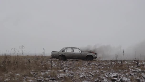 汽车爆炸, 侧视图, 汽车烧伤在灰色的领域 — 图库视频影像