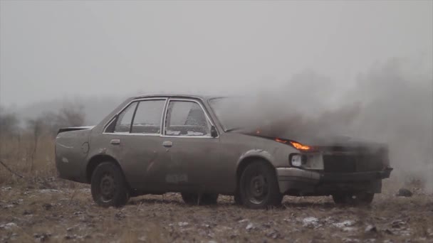 Έκρηξη αυτοκινήτου σε αργή κίνηση, καίει το αυτοκίνητο σε ένα γκρίζο πεδίο — Αρχείο Βίντεο