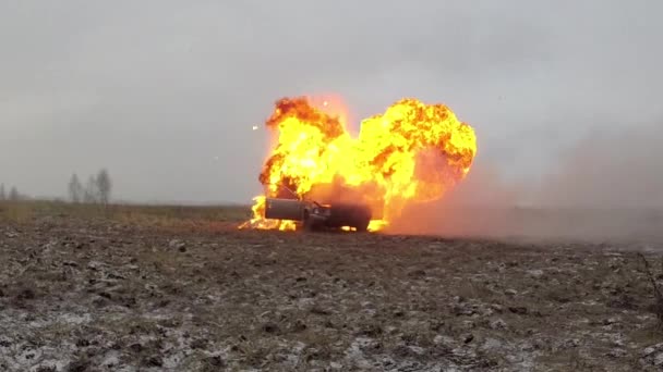 Взрыв автомобиля, вид спереди, автомобиль горит в сером поле — стоковое видео