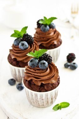 Çikolatalı kekler, çikolata kremalı ve taze dutlu..