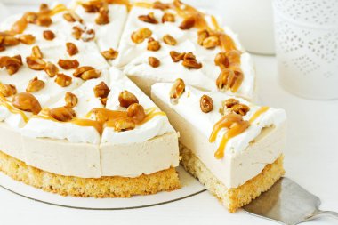 A wonderful caramel cheesecake with homemade caramel, nuts and chocolate. clipart