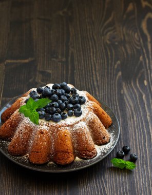 Yaban mersini ile vanilyalı kek (gugelhupf). koyu arka plan.