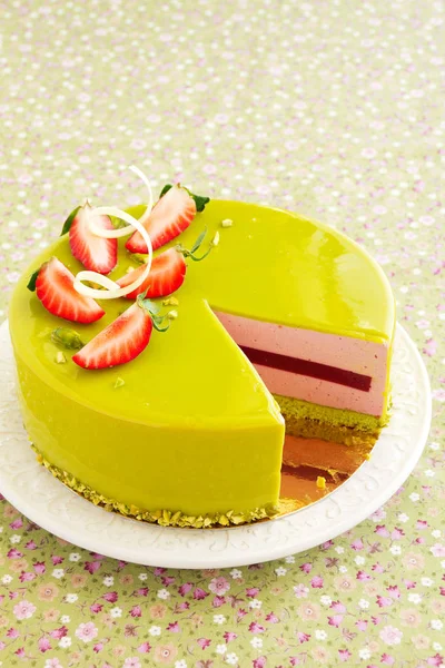 Delicious strawberry-pistachio mousse cake with a smooth glaze.