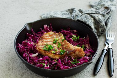 Kemiğe domuz pirzolası ve kırmızı lahana salatası..