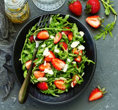 Roka, çilek ve badem ile taze salata. Seçici odak.