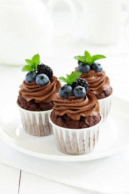 Çikolatalı kekler, çikolata kremalı ve taze dutlu..