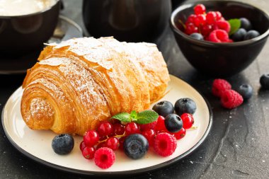 Lezzetli kahvaltı taze kruvasanlar ve olgun çilek ile