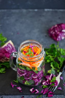 Salata, kırmızı lahana, havuç ve yeşillik bir kavanoza. sağlıklı beslenme. Seçici odak.