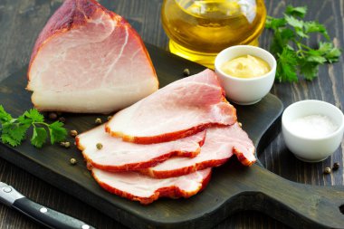 Ev yapımı füme jambon, dilimlenmiş. Yukarıdan görüntüleyin. Koyu arka plan.