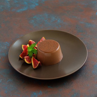 Ev yapımı lezzetli çikolata tatlı Panna cotta. Krem karamel, karamelli muhallebi, incir ile.