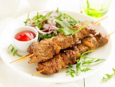 Sığır eti şiş kebap şişleri köri içinde üzerinde.