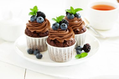 Çikolatalı kekler, çikolata kremalı ve taze dutlu..