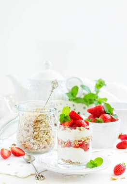 Granola, yoğurt ve çilekli bir bardakta tatlı. Yararlı bir kahvaltı..