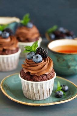 Çikolatalı kekler, çikolata kremalı ve taze dutlu..