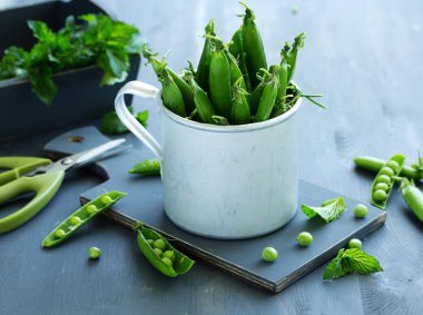 Yeşil bezelye ile gri bir arka plan üzerine bir fincan.