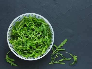 Yıkanmış taze roka yeşillik yıkamak için bir fincan. Yukarıdan görüntülemek.