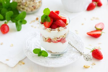 Granola, yoğurt ve çilekli bir bardakta tatlı. Yararlı bir kahvaltı..