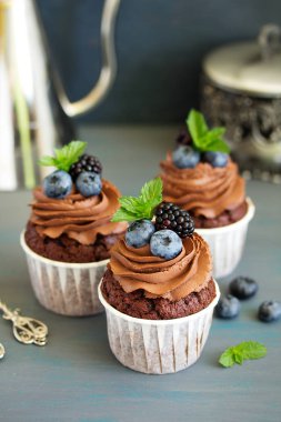 Çikolatalı kekler, çikolata kremalı ve taze dutlu..