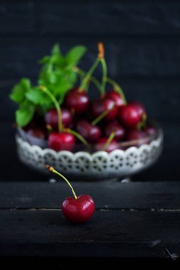 Masada bir fincan taze kiraz. Koyu arka plan. Seçici odak.