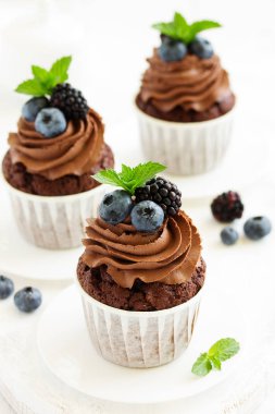 Çikolatalı kekler, çikolata kremalı ve taze dutlu..