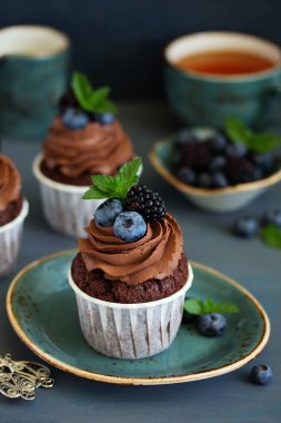 Çikolatalı kekler, çikolata kremalı ve taze dutlu..