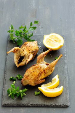 Otlar ve yeşillik ile lezzetli kızarmış bıldırcın.