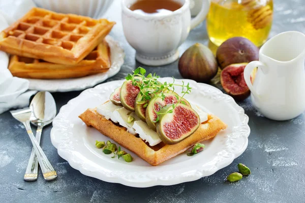 Wafers with figs, brie cheese and honey. Delicious wholesome breakfast.