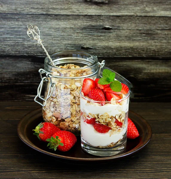 Granola, yoğurt ve çilekli bir bardakta tatlı. Yararlı bir kahvaltı..