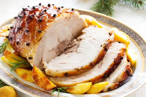 Roast pork with orange glaze, decorated with cloves.