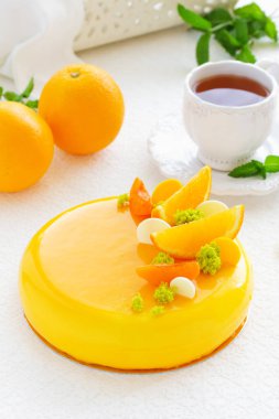 Kek turuncu mousse ve ayna sır içinde badem krokantom. Seçici odak.