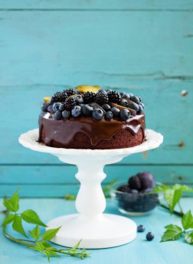 Yaban mersini, böğürtlen ve krema ile çikolatalı kek.