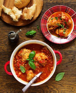 Biberiye ve fesleğen ile domates soslu fırında tavşan. İtalyan mutfağı.