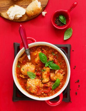 Biberiye ve fesleğen ile domates soslu fırında tavşan. İtalyan mutfağı.