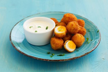 Bıldırcın yumurtası, derin kızarmış beyaz sos ile.